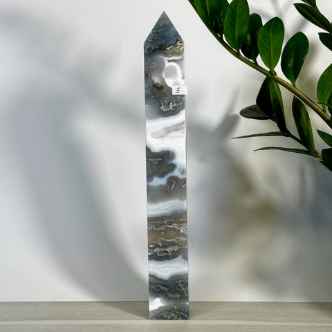 Tall, polished moss agate tower with striking white, gray, and brown swirling patterns.