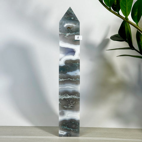 Tall, polished moss agate tower with white, grey, and green bands, featuring a pointed top.