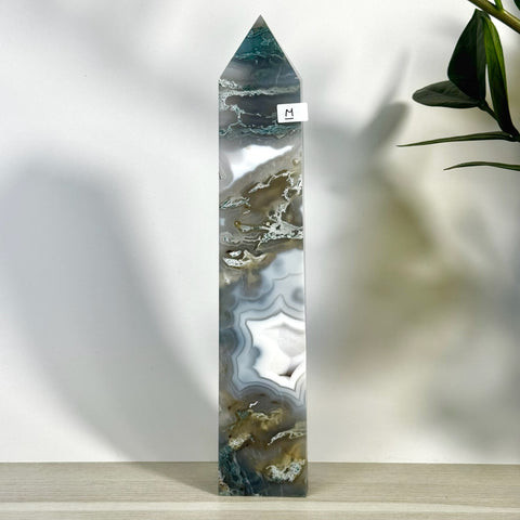 Tall, polished moss agate tower with white, green, and brown swirling patterns, featuring a pointed top.