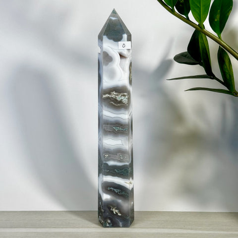 Tall, polished moss agate tower with striking white, grey, and green bands, featuring a pointed top.