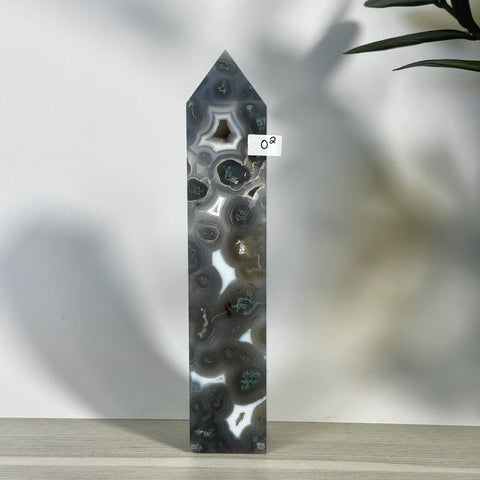 Tall, polished gray and white moss agate tower with intricate swirling patterns and green inclusions.