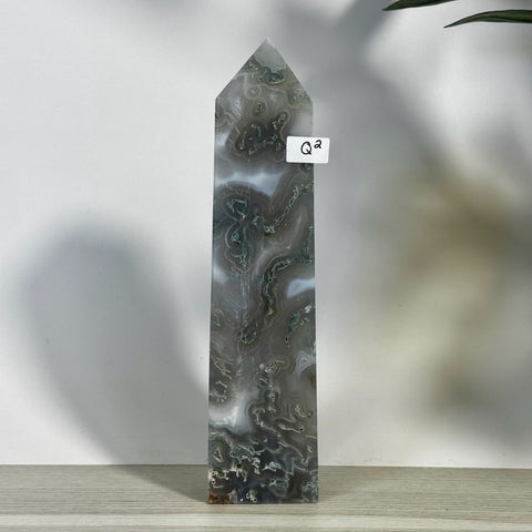 Tall, polished moss agate tower with intricate gray, white, and green patterns, labeled "Q2".