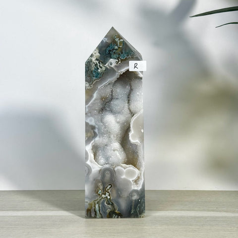 Tall moss agate tower (variant R) with a sparkling white geode cavity and natural grey-green patterns.