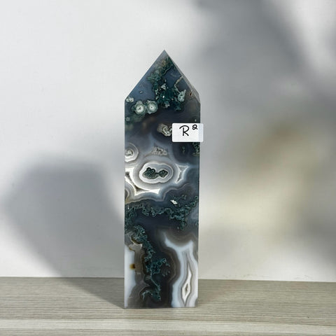 Tall, polished moss agate tower with intricate green, white, and gray swirling patterns.