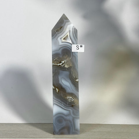 Tall, polished moss agate tower with white, gray, and brown swirling patterns, featuring a pointed top.