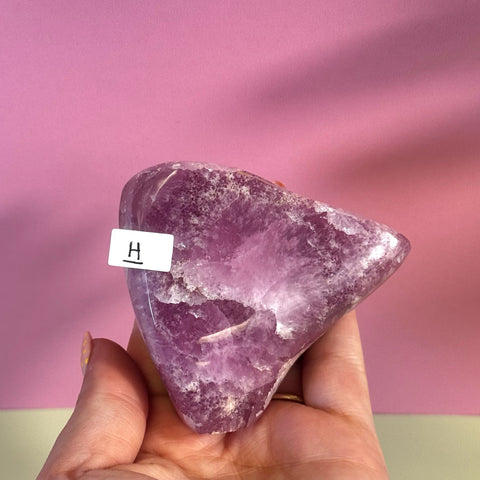 Statement Pink Aragonite Free Form, variant H, held in hand against a pink background.