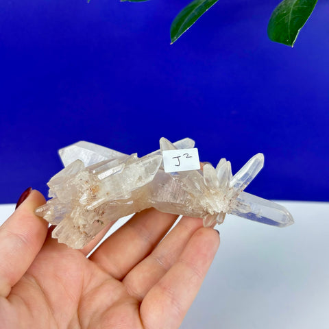Handheld Underworld Himalayan quartz cluster with clear, sharp crystal points and natural mineral inclusions.