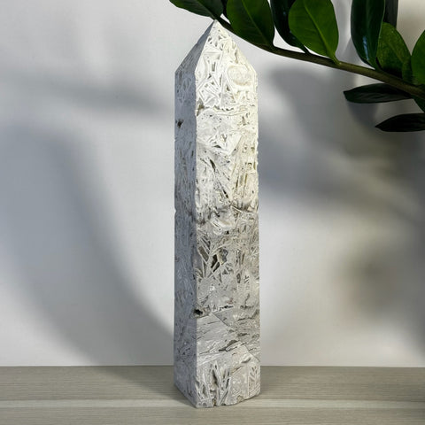 White Lace Agate Tower with intricate patterns, a pointed top, and a smooth, polished finish.