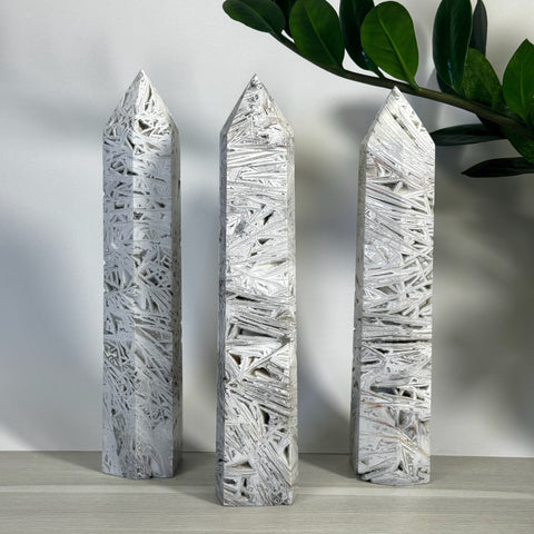 Three white lace agate towers with intricate, geometric patterns and pointed tops.